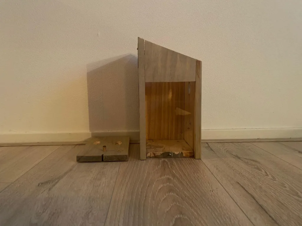 Zijpaneel vogelhuisje losgemaakt om lichtgaten in te zetten