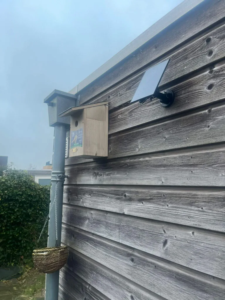 Zijkant van nestkast met camera en zonnepaneel